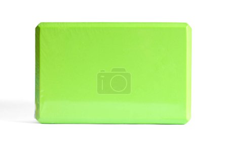 A green foam yoga block isolated on a white background. Concept of fitness equipment.