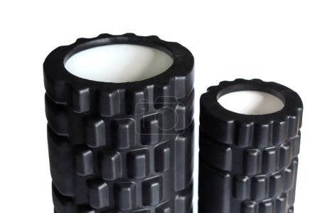The black foam massage rollers isolated on a white background. Foam rolling is a self myofascial release technique. Gym fitness equipment.