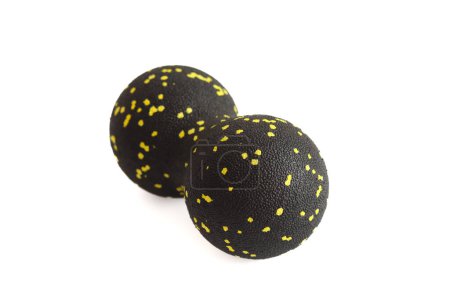 Black double ball or peanut ball massager with yellow dots isolated on a white background. Fitness equipment. Concept of myofascial release.