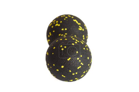 Schwarzer Doppelball oder Erdnussball Massagegerät mit gelben Punkten isoliert auf weißem Hintergrund. Fitnessgeräte. Konzept der myofaszialen Freisetzung.