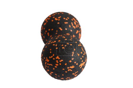 Black double ball or peanut ball massager with orange dots isolated on a white background. Fitness equipment. Concept of myofascial release.