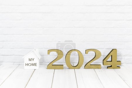 Téléchargez les photos : 2024 nouvel an et maison sur table en bois blanc sur fond blanc avec espace de copie, Concept immobilier - en image libre de droit