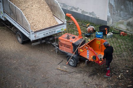 Foto de Mulhouse - France - 23 January 2023 - portrait on back view of worker using shredder machine in outdoor - Imagen libre de derechos