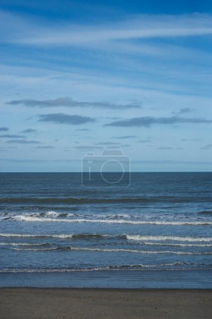 view of waves on the beach on blue sky background