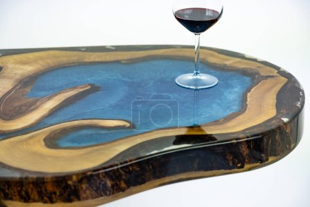 Couchtisch, Wohnzimmertisch vorhanden. Kunstharz handgemachter Holztisch. Auf weißem Hintergrund. Ein Glas Whisky auf dem Tisch. Glas Wein auf dem Tisch.