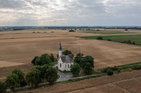 Photo for Drone photo of Church in the field in polish village Sidzina, Poland aerial drone photo view. Church in fields of grain - Royalty Free Image