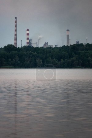 Photo for Industrial steel factory, iron works. Metallurgical plant. steelworks. Heavy industry in Europe. Air pollution from chimneys. Ironworks on a background of blue lake.  Nature and industry. - Royalty Free Image
