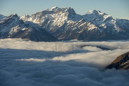 Téléchargez les photos : Montagne au-dessus des nuages. Station Civetta. Vue panoramique sur les montagnes des Dolomites en hiver, Italie. Station de ski à Dolomites, Italie. Vue aérienne par drone des pistes de ski et des montagnes dans les Alpes. - en image libre de droit