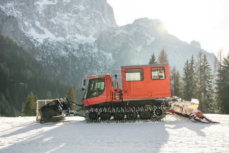 Téléchargez les photos : Piste toiletteuse en face des Alpes des Dolomites, Italie. dameuse à neige dans les Alpes dolomites en Italie. dameuse à neige dans les montagnes d'hiver. - en image libre de droit