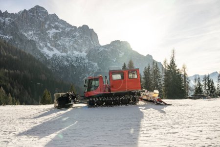 Téléchargez les photos : Piste toiletteuse en face des Alpes des Dolomites, Italie. dameuse à neige dans les Alpes dolomites en Italie. dameuse à neige dans les montagnes d'hiver. - en image libre de droit