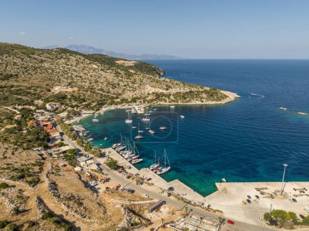 Foto de Foto aérea de aviones no tripulados de Agios Nikolaos - un pequeño puerto en la isla de Zante. Puerto en una isla griega con agua azul turquesa con muchos barcos y yates en el agua en Grecia, Zakynthos. - Imagen libre de derechos