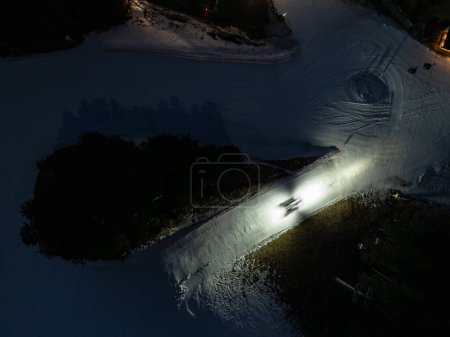 Foto de Vista aérea de aviones no tripulados de la ciudad de Andalo por la noche con montañas de fondo en invierno. Estación de esquí Paganella Andalo, Trentino-Alto Adige, Italia., Dolomitas italianas, Valle de Pagnella. Nieve cubierto de Dolomitas italianas en invierno. - Imagen libre de derechos