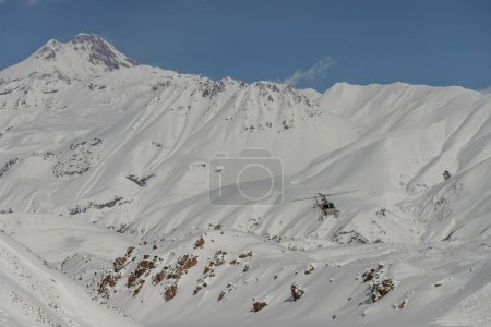Helicóptero en las montañas. Freeride heliboarding en el Cáucaso. Freeride snowboard en invierno. Freeride de helipuerto. Montar en polvo en snowborad. Freeride en las montañas del Cáucaso. 