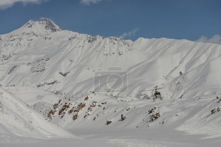 Hubschrauber in den Bergen. Freeride Heliboarding im Kaukasus. Freeride Snowboard im Winter. Heliboarding freeride. Reiten im Pulver auf Snowborad. Freeride im Kaukasus. 