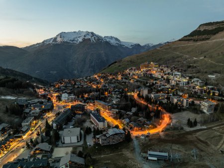 Photo aérienne de drone Blue Hour Alpes françaises en hiver, Rhône Alpes en France Europe. Village des deux alpes au printemps. Ville dans les montagnes alpines au coucher du soleil. Hiver Alpes françaises ville du drone