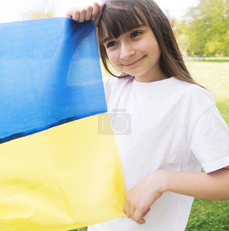 Rezad por Ucrania. Reza por la paz.Chica con bandera ucraniana. Feliz niño celebrando el Día de la Independencia. Día de la Bandera. Día de la Constitución. 