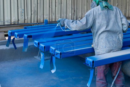 Photo for Paint Industry Steel Structure, The Painter is Working on Painting a Color Top Coat on a Steel Structure with a Spray Gun, at an Industrial Factory. - Royalty Free Image