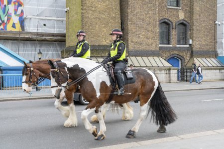 Photo for London, UK - March 21, 2024 :  London Metropolitan Police officers on horses on tower bridge. - Royalty Free Image