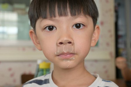 Foto de Pequeño chico desordenado con la boca sucia, divertido retrato de niño feliz, comida sabrosa - Imagen libre de derechos