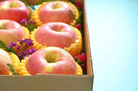 Foto de Beautiful pink apple in the box on blue background - Imagen libre de derechos