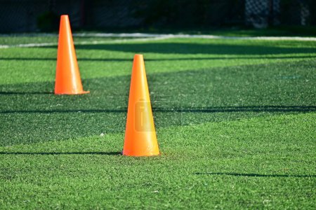 Foto de Campo de fútbol de césped verde artificial con conos de entrenamiento naranja - Imagen libre de derechos