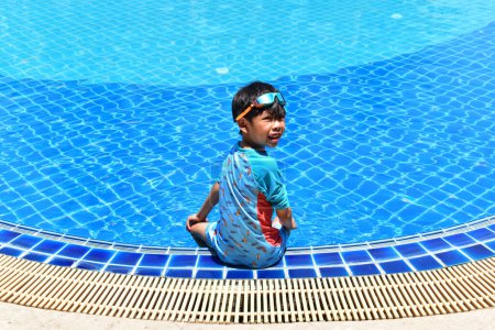 Foto de Lindo chico sentarse en la piscina, niño feliz - Imagen libre de derechos