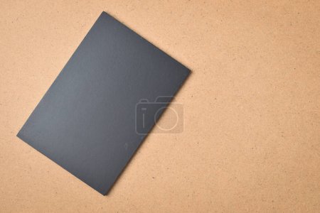 Foto de Cuaderno negro en blanco sobre fondo de textura de madera marrón - Imagen libre de derechos