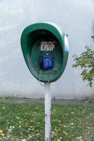 Téléchargez les photos : Vieux téléphone public bleu (téléphone public). Texture arrière-plan d'un téléphone payant de rue en fer vintage non fonctionnel avec boutons - en image libre de droit