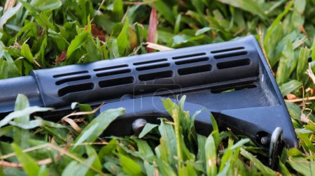 Téléchargez les photos : Gros plan air doux pistolet pliable stock mis sur l'herbe - en image libre de droit