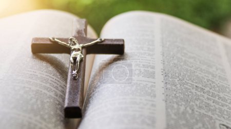 Foto de Cerrar cruz de madera marrón oscuro en libros antiguos con fondo borroso - Imagen libre de derechos