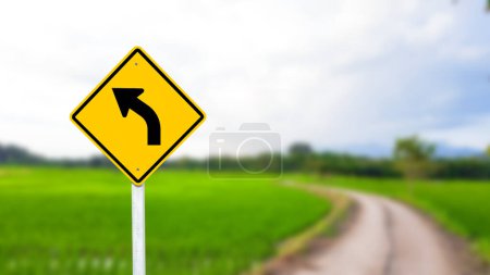 A black left-curved arrow is displayed on a bright yellow sign. The bold arrow indicates a left turn ahead, ensuring drivers are aware of the upcoming change in direction. The vivid yellow background enhances visibility for safe navigation.
