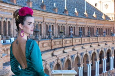 Téléchargez les photos : Belle jeune femme avec robe à volants vert typique et danse flamenco sur la place d'Espagne à sevilla, andalousie, elle est sur un balcon de la célèbre place. 16 novembre, Journée internationale du flamenco - en image libre de droit