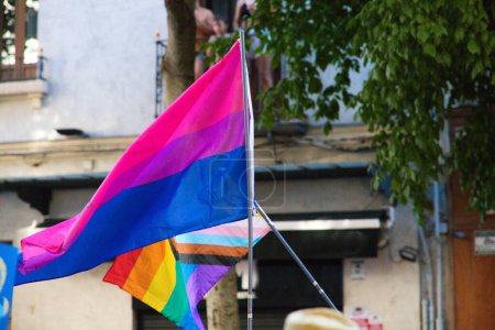 The bisexual flag and the progressive gay pride flag fly at the seville gay pride event. Concept of equality and gay rights