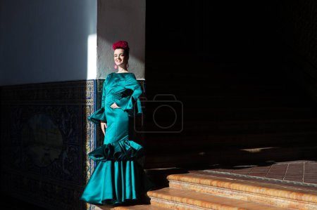 Téléchargez les photos : Jeune et belle femme avec robe verte à volants et flamenco dansant est sur les escaliers de la place d'Espagne à Séville, andalousie. La femme a de l'art et est typique de l'Espagne - en image libre de droit