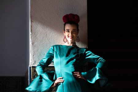 Téléchargez les photos : Jeune et belle femme avec robe verte à volants et flamenco dansant est sur les escaliers de la place d'Espagne à Séville, andalousie. La femme a de l'art et est typique de l'Espagne - en image libre de droit