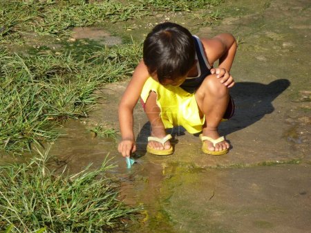 Un enfant philippin joue dans l'eau