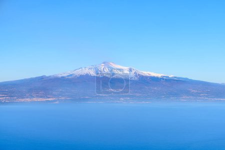 Foto de Vista aérea del Monte Etna, un volcán activo, un pico nevado sobre la ciudad de Catania, desde el Estrecho de Messina en el mar Mediterráneo, Sicilia, Italia - Imagen libre de derechos