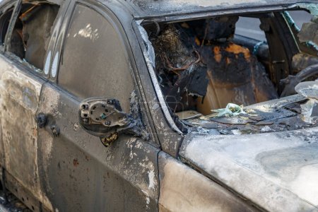 Photo for Windows shatter from the explosion. Setting fire to cars of a terrorist attack. Remains of a burned car. Burned out car on roadside down in the middle of the street. Burnt new car, vandalism, mafia. - Royalty Free Image
