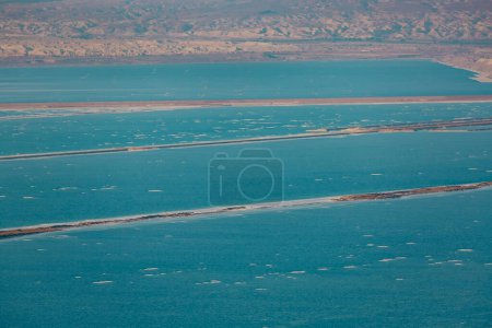 Mountains and blue sea landscape. Industrial facilities. Pontoon mining potash and mud from the Dead Sea. Salt extraction, production facility region in Israel. Coast Dead Sea,  salt crystals beach