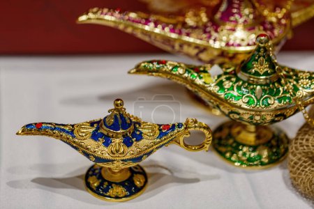 Photo for Aladdin's mysterious lamp. Precious golden magic lamp on blurred background, fairy tales and wish fulfillment concept. Background with selective focus and copy space. Close up of gold decorative lamps - Royalty Free Image