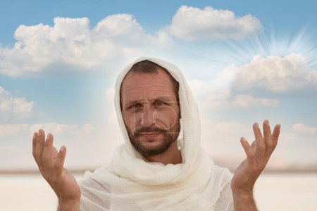 Ein Mann, der mit erhobenen Händen im Gebet steht. Er ist in ein weißes Tuch gekleidet, das ein Gefühl der Reinheit und Spiritualität widerspiegelt. Das Bild fängt einen Moment der Anbetung, Meditation und Dankbarkeit gegenüber Gott ein