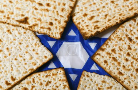 Téléchargez les photos : Matzo, un pain plat sans levain, disposé autour d'une étoile bleue et blanche de David. L'étoile est bien en vue, symbolisant l'identité et le patrimoine juifs, rendant cette image représentative de la Pâque juive - en image libre de droit