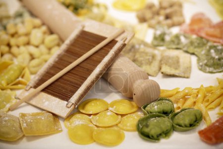Téléchargez les photos : Crus différents types de pâtes italiennes avec de la farine sur la table - en image libre de droit