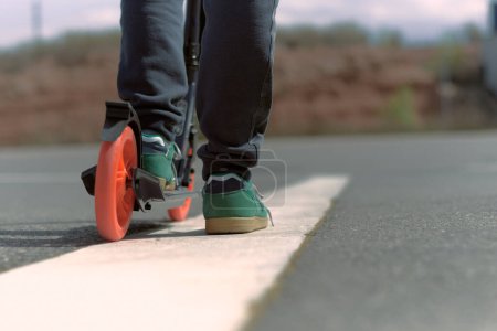 Foto de Equilibrio en la línea: rueda scooter junto a la línea de asfalto blanco, con espacio libre - Imagen libre de derechos