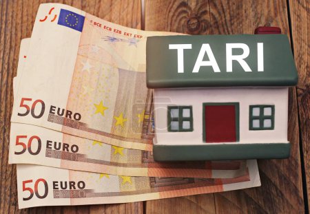 Téléchargez les photos : Maison avec billets en euros et le texte "Tari" concept de la taxe iItalian - en image libre de droit