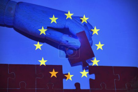 Drapeau européen avec une main de robot avec un puzzle .