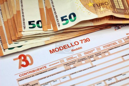 Foto de Muchos billetes en euros con el Modello 730 como fondo, traduciéndose en italiano como declaración de ingresos, concepto de pago de impuestos . - Imagen libre de derechos