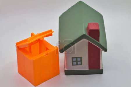 Téléchargez les photos : Camion poubelle jouet et poubelles debout à proximité d'un modèle de maison miniature à l'extérieur. Gestion des déchets dans les zones rurales. - en image libre de droit