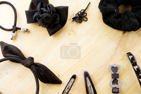 Photo for Black hair accessories on table wood background with space. - Royalty Free Image