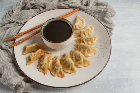 Photo for Japanese Gyoza dumplings,fried, with sauce, top view, without people, tinted, selective focus, - Royalty Free Image